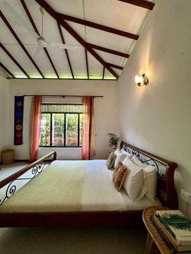 a bedroom with a large bed and a window at One Bhakthi in Ahangama