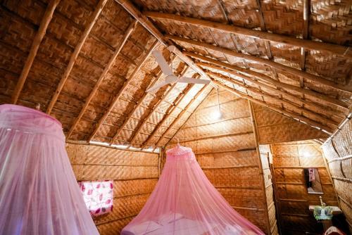 a room with two gowns hanging from a ceiling at Hampi Waterfall Cottages in Hampi
