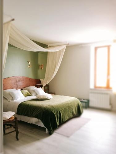 une chambre avec un lit à baldaquin dans l'établissement La Ferme de Plénoise Chambre & Table d'hôtes, à Fricambault