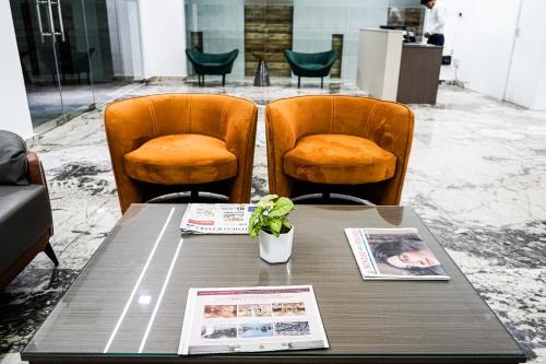 a wooden table with two chairs and a table with at The Hoften Sukh Vasa, Sector 51 & Golf Course Ext Road in Gurgaon