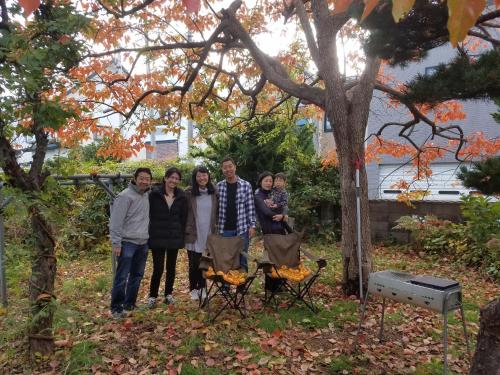 a group of people posing for a picture under a tree at AomoriOutdoorHouse in Aomori