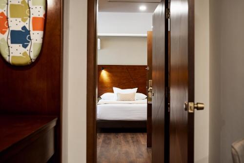 a door leading to a bedroom with a bed at Hotel Mitru Sur in La Paz
