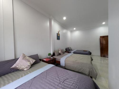 a room with three beds in a room at Orchid 101 in Kampot