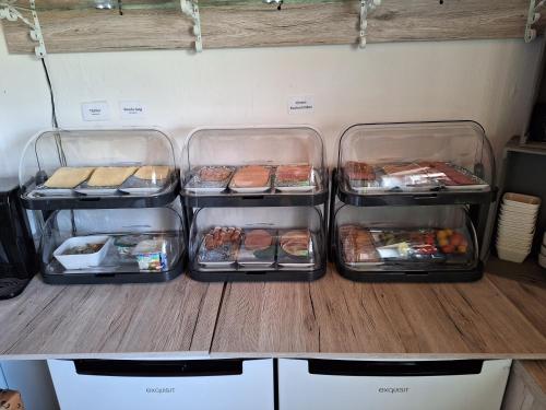 vier dienbladen met voedsel op een aanrecht in een koelkast bij Hotel & Pension Haus Dewenter in Lichtenau