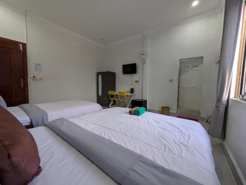 a bedroom with two beds and a tv in it at Orchid 101 in Kampot