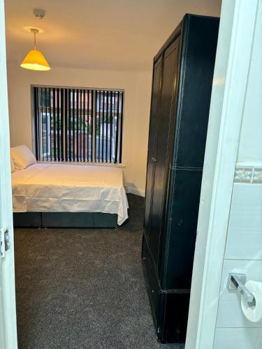 a bedroom with a bed and a large window at Stainless Guests house in Dudley