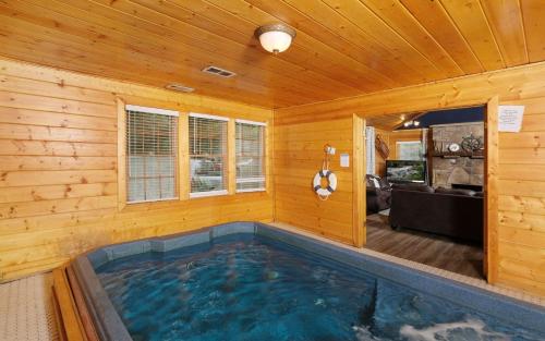 a swimming pool in a wooden room with a house at Poolin Around in Gatlinburg