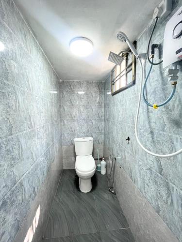 a bathroom with a toilet and a shower at Baiduri Homestay in Kota Tinggi