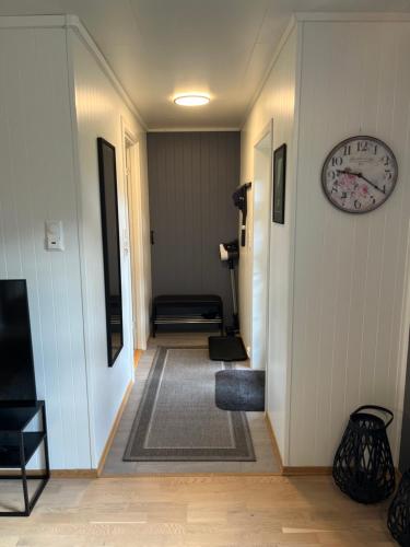 a hallway with a clock on the wall and a couch at Beautiful view - close to the sea, mountains and nature in Kvaløya