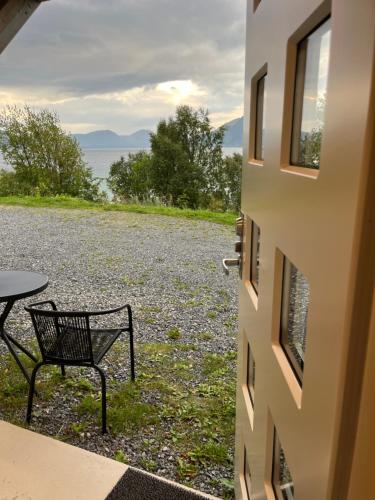 a bench sitting outside of a building with a view of the water at Beautiful view - close to the sea, mountains and nature in Kvaløya