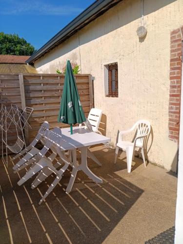 a table and two chairs and an umbrella on a patio at Jaureguiberry in Saint-Martin-de-Hinx