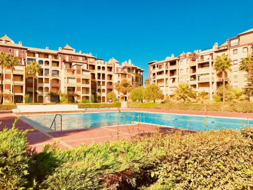a tennis court in front of some apartment buildings at Alcaudón, Isla Canela - By AC REAL in Isla Canela