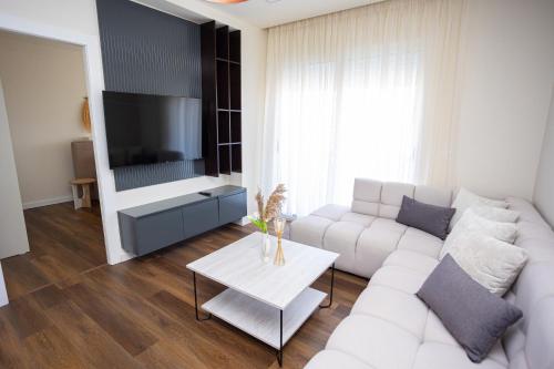 a living room with a white couch and a tv at iunn apartment 2 in Vlorë