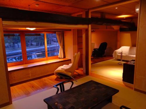 a room with a bed and a desk and a window at ワインとお宿千歳Chitose in Monju