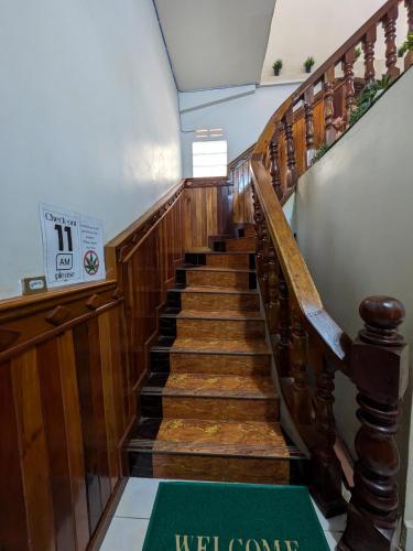 a wooden staircase with a green sign on it at Orchid 101 in Kampot