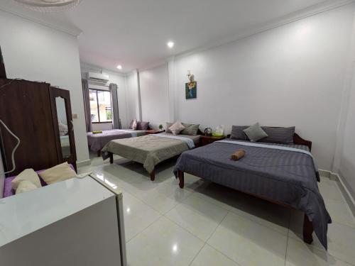 a living room with two beds and a couch at Orchid 101 in Kampot