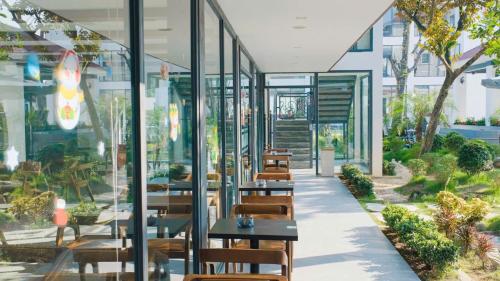 a restaurant with tables and chairs in a building at Sen Plaza Hotel in An Nhiên