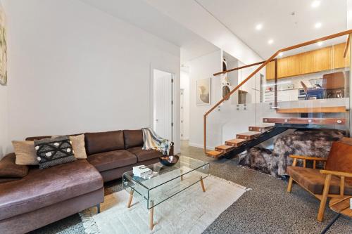 a living room with a couch and a fireplace at Loft Retreat in Auckland