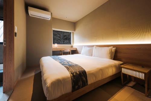 a bedroom with a large bed and a window at Ski Inn Hakuba, Iwatake in Hakuba