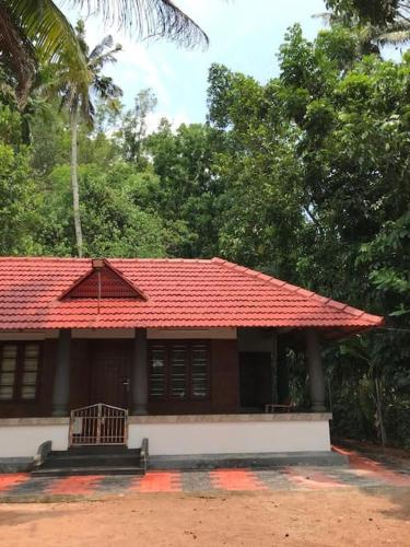 a small house with a red roof and trees at Quite and peaceful in Perumanseri