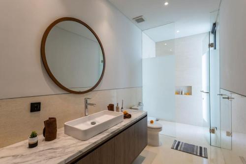 ein Badezimmer mit Waschbecken und Spiegel in der Unterkunft BRAND NEW Modern Gem Luxury 3bd Villa in Umalas in Kerobokan
