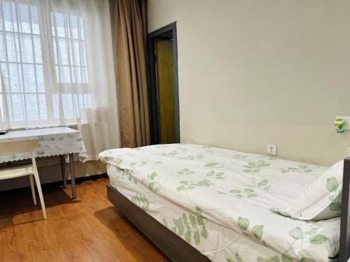 a bedroom with a bed and a desk and window at Fengma Feiyang Hostel in Lhasa
