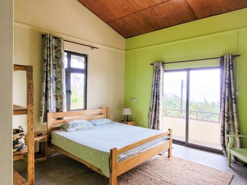 a bedroom with a bed and a large window at Lakaz Roussette - Large 4BR Villa with King Beds in Rodrigues Island