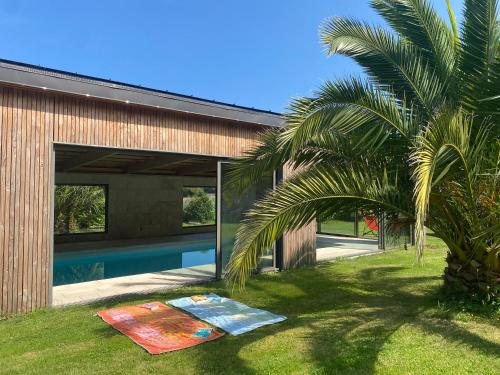 une maison avec une piscine à côté d'un palmier dans l'établissement Kerguen Kozh, à Plobannalec-Lesconil