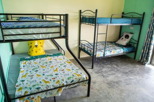 a room with two bunk beds and a chair at Lakaz Roussette - Large 4BR Villa with King Beds in Rodrigues Island