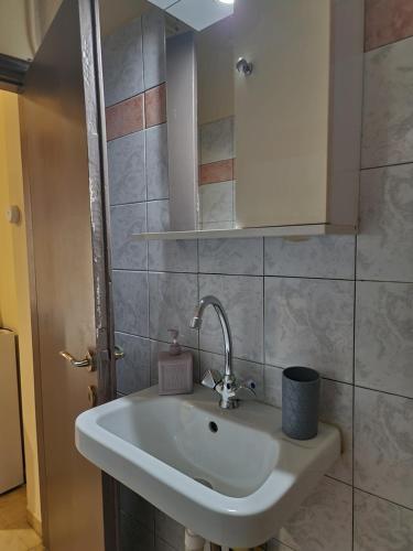 un bagno con lavandino e specchio di Diana's Cozy 12 Studio a Ioannina