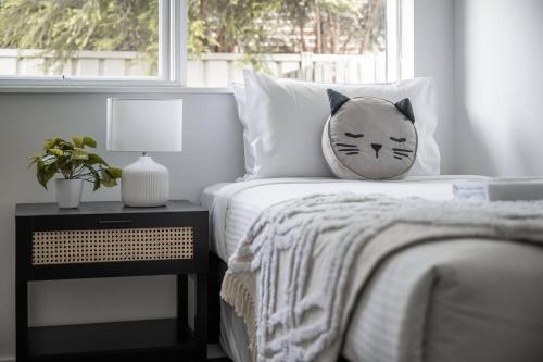 a pillow on a bed next to a window at Ultra-convenient 2 Bedroom Gem at Chadstone in Carnegie