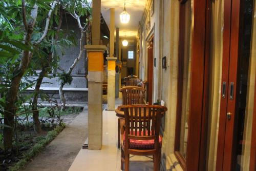 a hallway with two wooden chairs in a building at Tagel Karsa House in Ubud