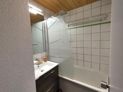 une salle de bain avec un lavabo, une douche et un miroir dans l'établissement Appartement 5 p Belle Plagne Skis aux pieds, à Belle Plagne