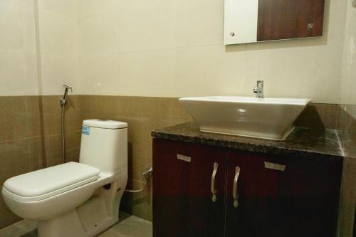 a bathroom with a white toilet and a sink at Hotel Gateway Suites Bangalore Airport in Yelahanka