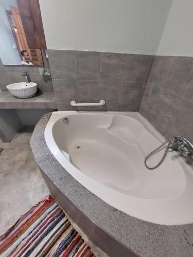a large white bath tub in a bathroom at Lakaz Roussette - Large 4BR Villa with King Beds in Rodrigues Island
