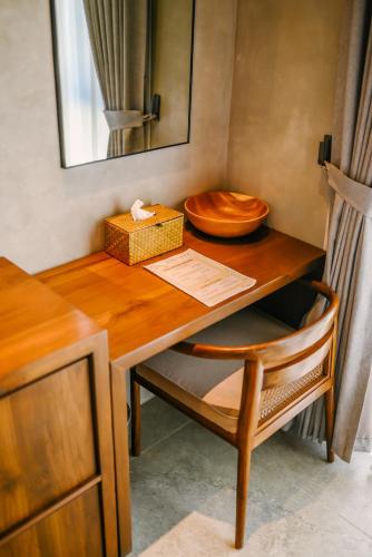 a wooden table with a bowl on top of it at TANA Beach Villas in Lian