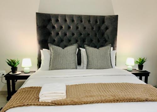 a bedroom with a large bed with two lamps at Olive Villa Self Catering Apartments in Swakopmund