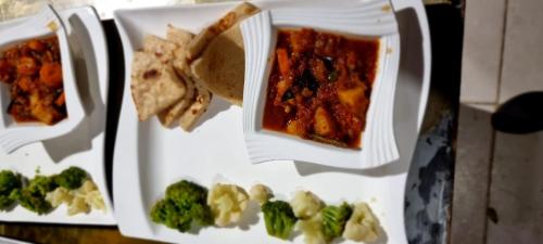 a plate of food with broccoli and other foods at Amanya 2 Bedroom Self Catering Tent in Amboseli