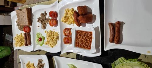 two white plates with different types of food on them at Amanya 2 Bedroom Self Catering Tent in Amboseli