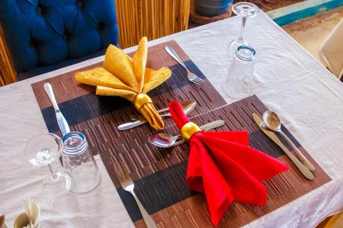 a table with a red napkin and utensils on it at Amanya 2 Bedroom Self Catering Tent in Amboseli