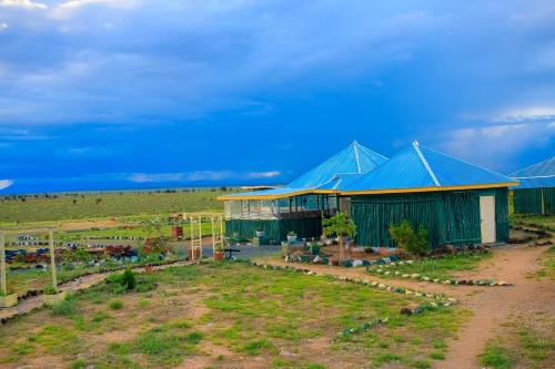 a large building with blue roofs in a field at Amanya 2 Bedroom Self Catering Tent in Amboseli