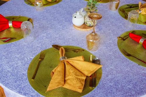 a table with green plates and napkins on it at Amanya 2 Bedroom Self Catering Tent in Amboseli