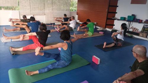 a group of people sitting in a yoga class at tippys beach resort in Kovalam
