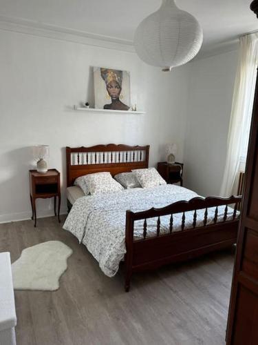 une chambre avec un grand lit et une lampe dans l'établissement L'Escale Colombe, Appartement à Concarneau, à Concarneau