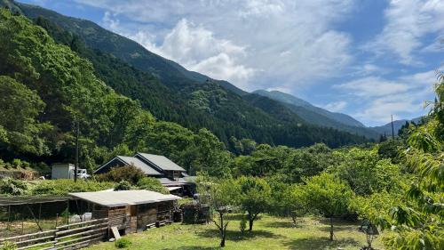 a house in a field with mountains in the background at リラシャンティRelashanti in Soni