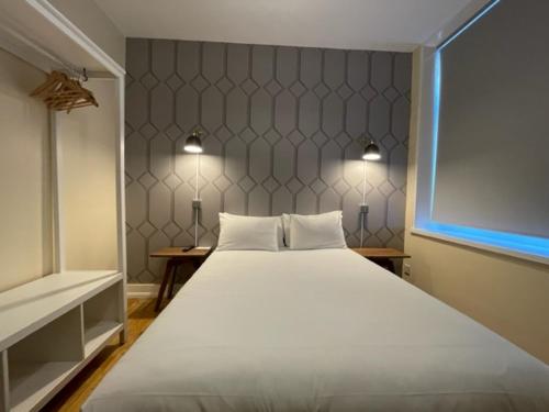 a bedroom with a large white bed and a window at RIOSHOUSE Henley in Henley on Thames