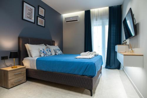 a bedroom with a bed with blue walls and a window at KLELIA Luxury Apartment in Alexandroupoli