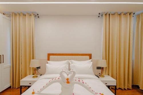 a white bed with a heart made out of pillows at Alokah Kashi in Varanasi