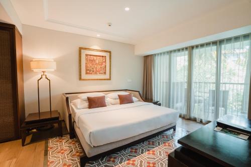 a bedroom with a bed and a large window at Ramayana Suites and Resort in Kuta