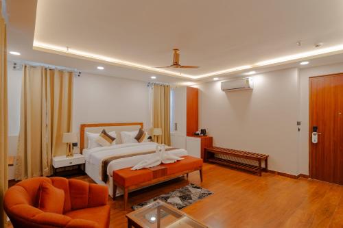 a bedroom with a bed and a couch and a chair at Alokah Kashi in Varanasi